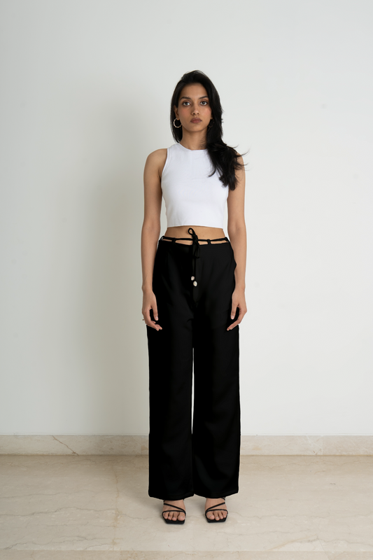 These black coloured wide legged trousers in knitted fabric. High waist with a zip fly and a concealed button and hook-and-eye fastener. Diagonal side pockets, and wide, straight legs with drawstrings attached to the belt for added comfort.